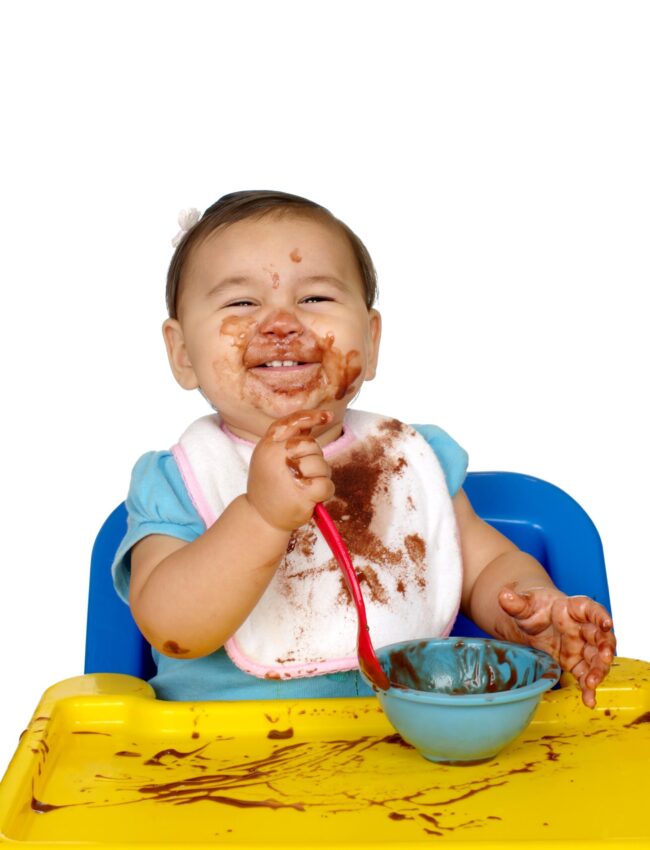 baby girl eating chocolate pudding, messy face